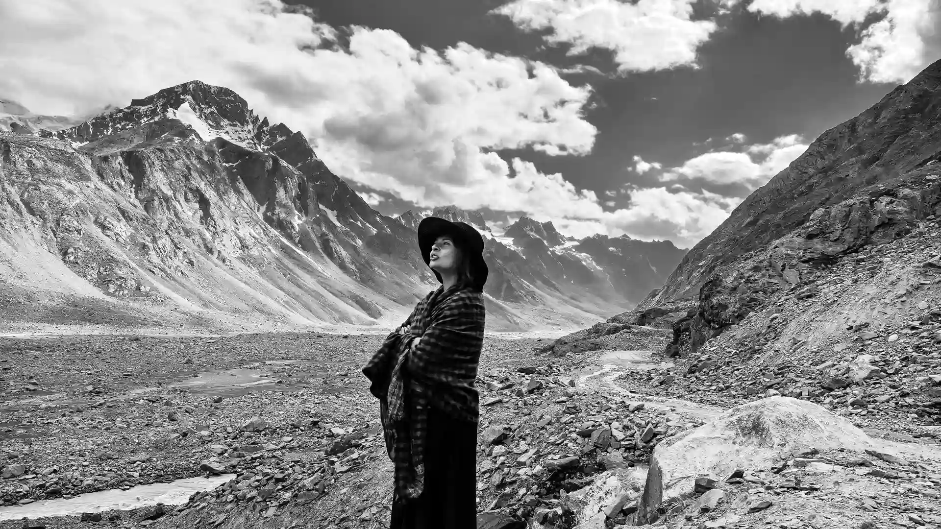 Explore a striking portrait from The Fstop Life's Spiti Valley expedition, featuring a subject in black attire and hat standing against the vast, rugged landscapes of Spiti. Discover more captivating imagery at www.thefstoplife.com.